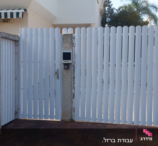 שער לבן עם קיר אבן לידו